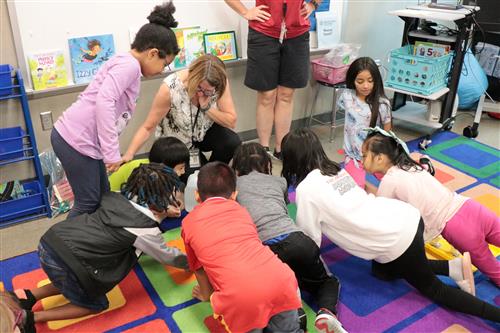Students and staff working together on the floor